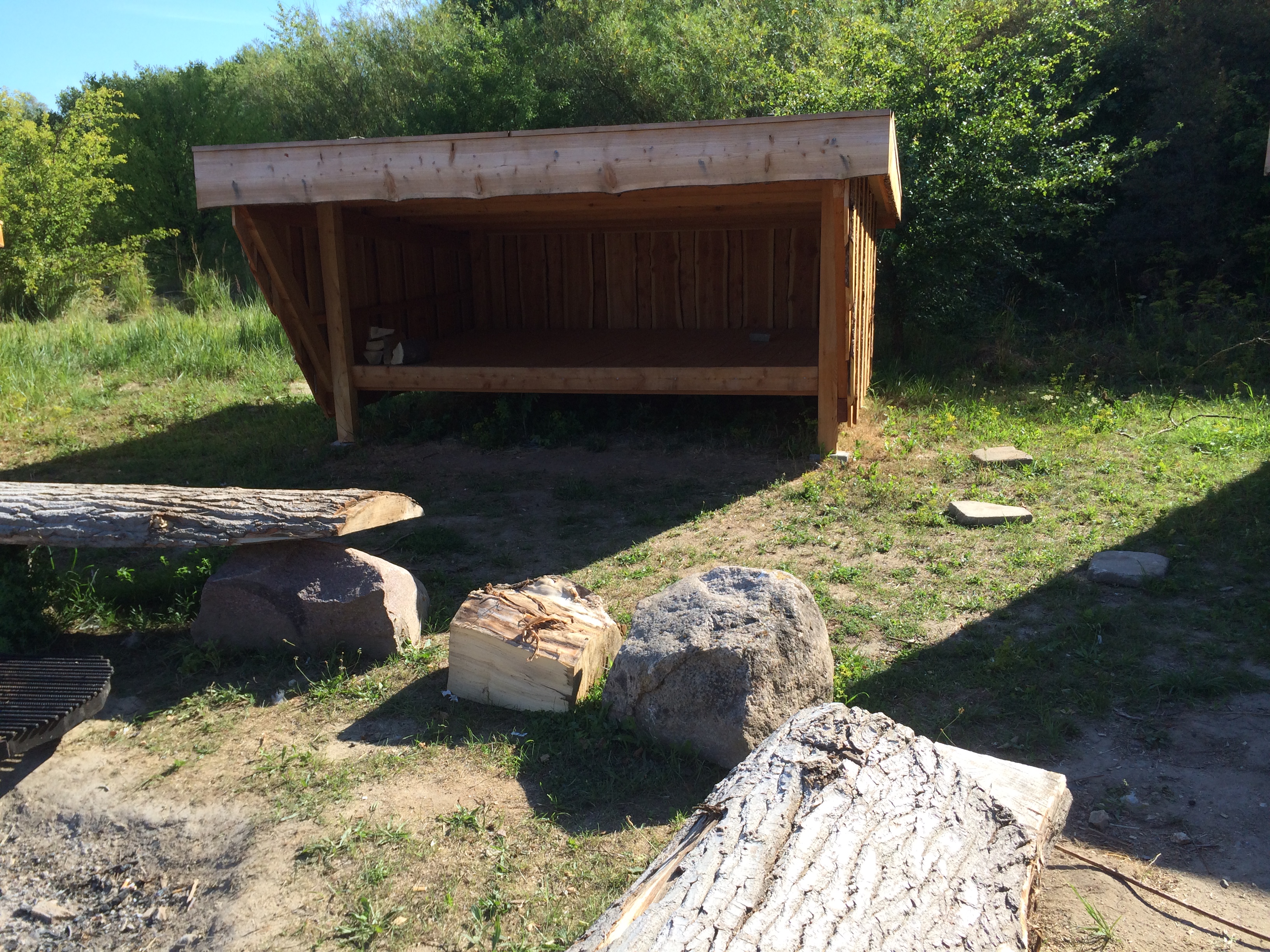 Foto viser et shelter lavet af træ, set forfra